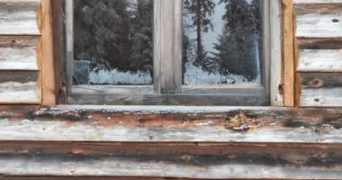 Splendid mountain winter landscape with secluded small wooden alpine cottage among the fir trees fully covered by snow during snow fall. Hi quality 4K slow motion footage. 