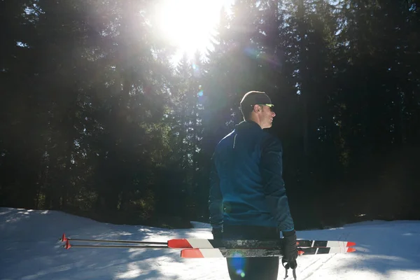 形象英俊的男性运动员 手拿越野滑雪板和护目镜 在雪地的森林里接受训练 健康的冬季生活方式概念 — 图库照片