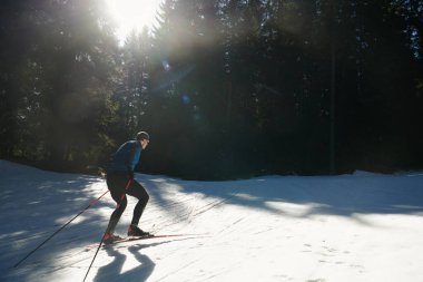 Nordic skiing or Cross-country skiing classic technique practiced by man in a beautiful panoramic trail at morning. Selective focus 