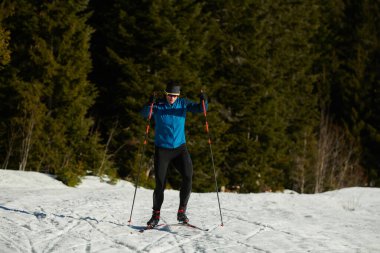 Nordic skiing or Cross-country skiing classic technique practiced by man in a beautiful panoramic trail at morning. Selective focus 