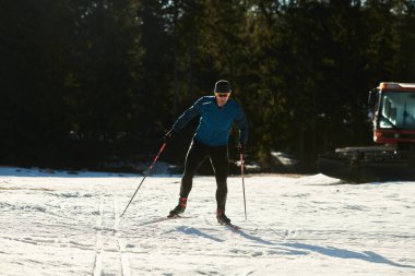 Nordic skiing or Cross-country skiing classic technique practiced by man in a beautiful panoramic trail at morning. Selective focus 