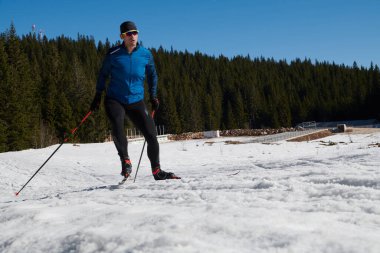 Nordic skiing or Cross-country skiing classic technique practiced by man in a beautiful panoramic trail at morning. Selective focus 