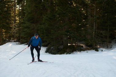 Nordic skiing or Cross-country skiing classic technique practiced by man in a beautiful panoramic trail at morning. Selective focus 