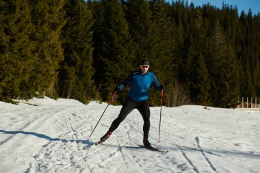 Nordic skiing or Cross-country skiing classic technique practiced by man in a beautiful panoramic trail at morning. Selective focus 