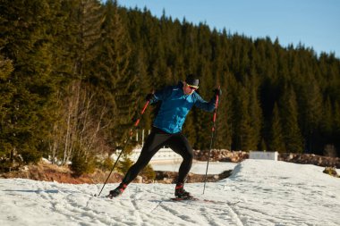 Nordic skiing or Cross-country skiing classic technique practiced by man in a beautiful panoramic trail at morning. Selective focus 