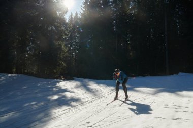 Nordic skiing or Cross-country skiing classic technique practiced by man in a beautiful panoramic trail at morning. Selective focus 