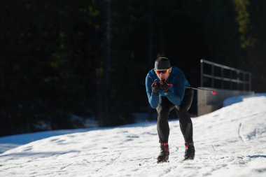 Nordic skiing or Cross-country skiing classic technique practiced by man in a beautiful panoramic trail at morning. Selective focus 