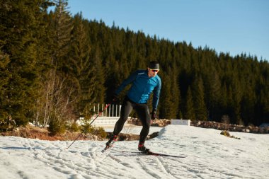Nordic skiing or Cross-country skiing classic technique practiced by man in a beautiful panoramic trail at morning. Selective focus 