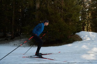 Nordic skiing or Cross-country skiing classic technique practiced by man in a beautiful panoramic trail at morning. Selective focus 