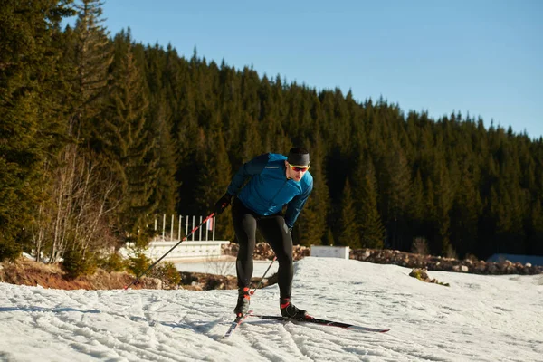 Nordic skiing or Cross-country skiing classic technique practiced by man in a beautiful panoramic trail at morning. Selective focus 