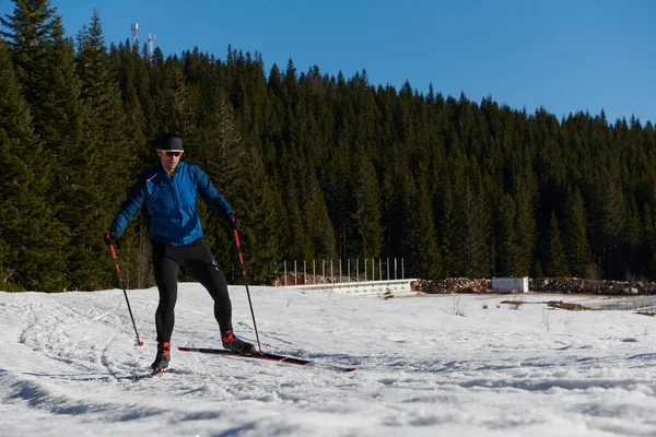 Nordic skiing or Cross-country skiing classic technique practiced by man in a beautiful panoramic trail at morning. Selective focus