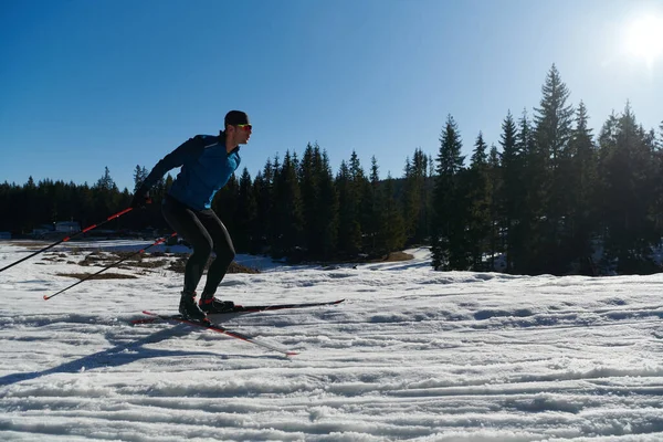 Nordic skiing or Cross-country skiing classic technique practiced by man in a beautiful panoramic trail at morning. Selective focus