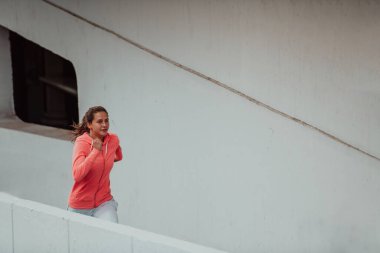 Women in sports clothes running in a modern urban environment. The concept of a sporty and healthy lifestyle. 