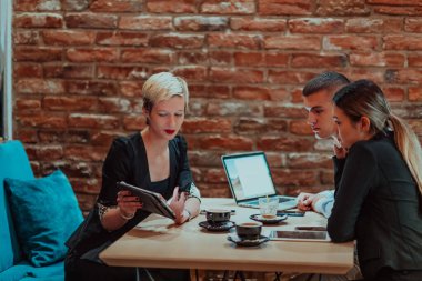 Happy businesspeople smiling cheerfully during a meeting in a coffee shop. Group of successful business professionals working as a team in a multicultural workplace. 