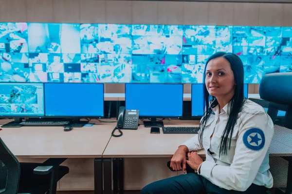 在数据系统控制室办公室工作的女性安保操作员技术操作员在有多个显示器的工作站工作 安保员在多个监视器上工作 — 图库照片
