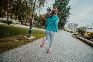 Women in sports clothes running in a modern urban environment. The concept of a sporty and healthy lifestyle. 