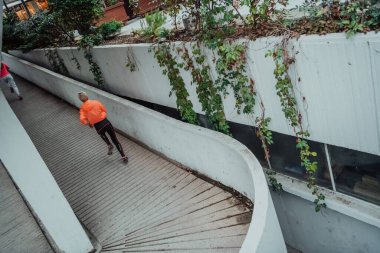 Two women in sports clothes running in a modern urban environment. The concept of a sporty and healthy lifestyle. 
