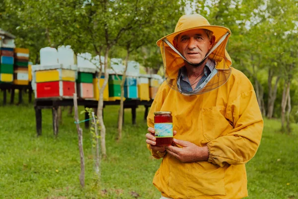 Beekeeper Holding Jar Honey His Hand While Standing Meadow Surrounded — Stok fotoğraf