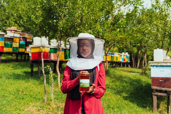 彼女の手に蜂蜜の瓶を保持する蜂蜜農場の養蜂部門におけるアラブの投資家の肖像画 — ストック写真