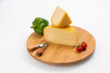 Bosnian traditional cheese served on a wooden container with peppers, parade and onions isolated on a white background.