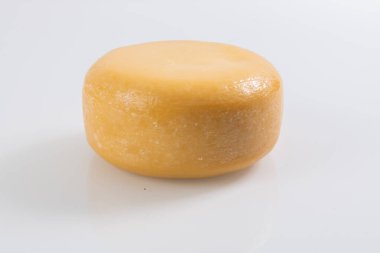 A piece of fresh processed cheese isolated on a white background. 