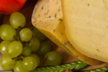 Bosnian traditional cheese served on a wooden container with peppers, parade and onions isolated on a white background.