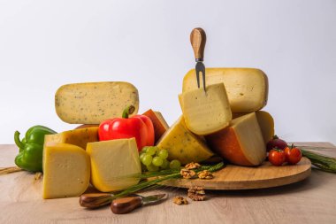 Bosnian traditional cheese served on a wooden container with peppers, parade and onions isolated on a white background.