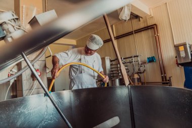 A cheese makser working in the industry on various machines with the help of which cheese is processed. Small business concept. 