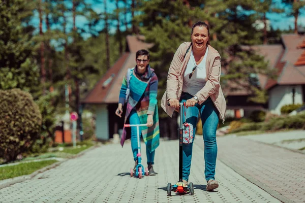Two Women Having Fun Park While Riding Scooter — Φωτογραφία Αρχείου