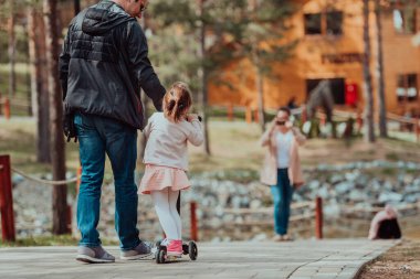 Family time in the park. Father have fun with his daughter in the park, playing fun games and spending time together. 