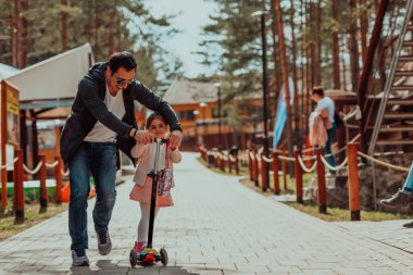 Family time in the park. Father have fun with his daughter in the park, playing fun games and spending time together. 