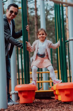 Family time in the park. Father have fun with his daughter in the park, playing fun games and spending time together. 