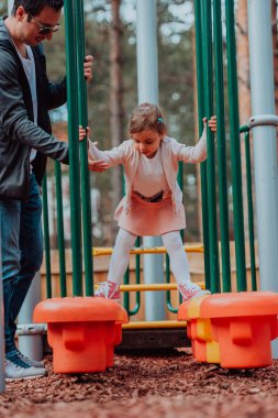 Family time in the park. Father have fun with his daughter in the park, playing fun games and spending time together. 