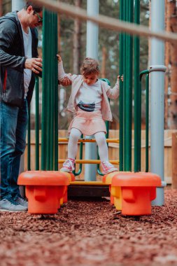 Family time in the park. Father have fun with his daughter in the park, playing fun games and spending time together. 