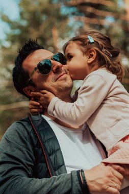 Family time in the park. Father have fun with his daughter in the park, playing fun games and spending time together. 