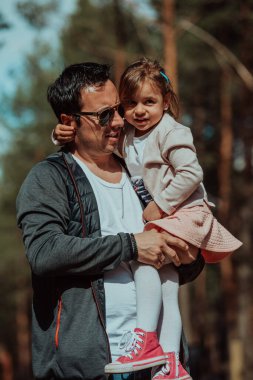 Family time in the park. Father have fun with his daughter in the park, playing fun games and spending time together. 