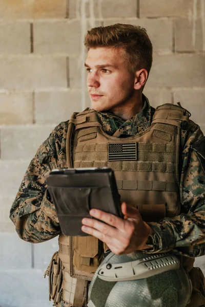 Voják Pomocí Tabletu Počítače Proti Staré Cihlové Zdi — Stock fotografie