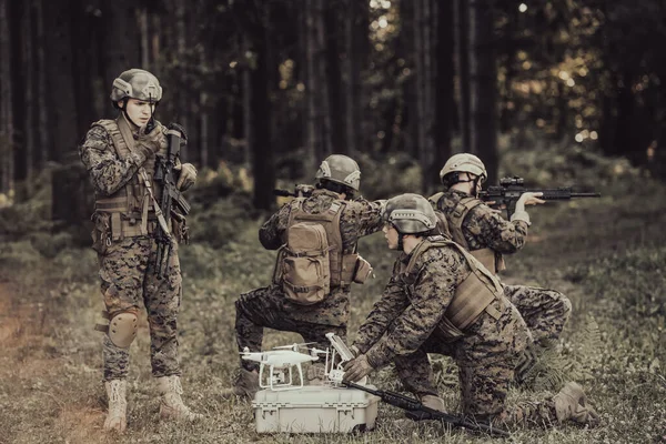 在森林军事行动中 现代战争士兵小队正在使用无人机进行侦察和监视 — 图库照片