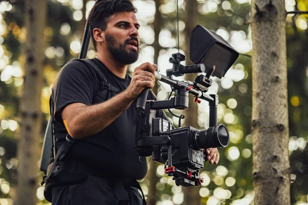プロの映画ビデオカメラとビデオカメラジンバル安定化装置は森の中でアクションで兵士の撮影を取ります — ストック写真