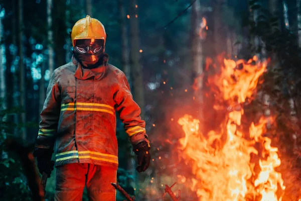 Firefighter at job. Firefighter in dangerous forest areas surrounded by strong fire. Concept of the work of the fire service. H