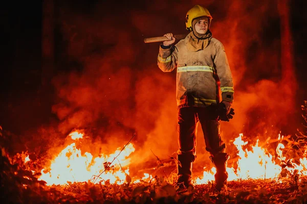 Firefighter at job. Firefighter in dangerous forest areas surrounded by strong fire. Concept of the work of the fire service.