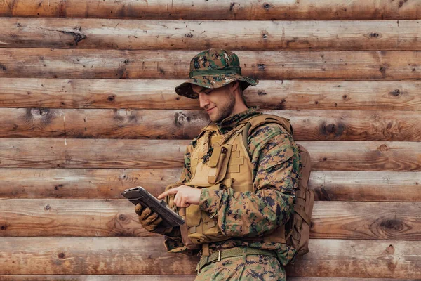 Солдат Использует Планшетный Компьютер Против Старой Деревянной Стены Военном Лагере — стоковое фото