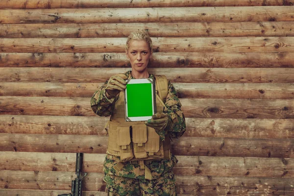 Kobieta Żołnierz Pomocą Komputera Tablet Przeciwko Starej Drewnianej Ścianie Obozie — Zdjęcie stockowe