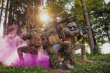 Bir grup modern savaş askeri tehlikeli uzak orman bölgelerinde savaşıyor. Bir grup asker modern silahlarla düşman hattında savaşıyor. Savaş ve askerlik kavramı.