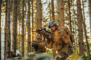 Bir grup modern savaş askeri tehlikeli uzak orman bölgelerinde savaşıyor. Bir grup asker modern silahlarla düşman hattında savaşıyor. Savaş ve askerlik kavramı.