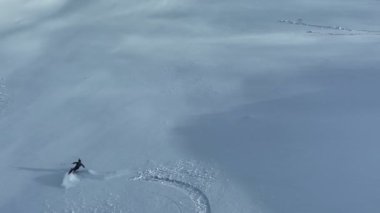 Sinema, tepeden aşağı serbest kayak. İnanılmaz bir dağ manzarası olan taze, derin karda kayak. Freeride atletleri muhteşem bir manzara ile piste kayak dönüşlerini gösteriyorlar. Yüksek kalite 4k görüntü