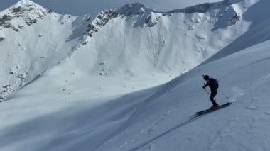 Sinema, tepeden aşağı serbest kayak. İnanılmaz bir dağ manzarası olan taze, derin karda kayak. Freeride atletleri muhteşem bir manzara ile piste kayak dönüşlerini gösteriyorlar. Yüksek kalite 4k görüntü