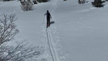 Kışın taze kar mevsiminde dağlarda kameranın önünden geçen hava kayaklı adam. Deri yokuşunda bir sıra halinde kayak turu. Toz günü. kayak tatili konsepti. Yüksek kalite 4k