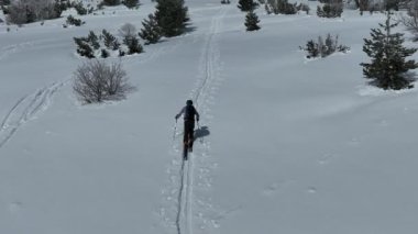 Kışın taze kar mevsiminde dağlarda kameranın önünden geçen hava kayaklı adam. Deri yokuşunda bir sıra halinde kayak turu. Toz günü. kayak tatili konsepti. Yüksek kalite 4k