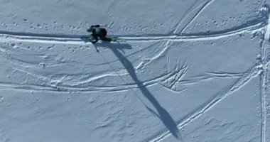 Kışın taze kar mevsiminde dağlarda kameranın önünden geçen hava kayaklı adam. Deri yokuşunda bir sıra halinde kayak turu. Toz günü. kayak tatili konsepti. Yüksek kalite 4k